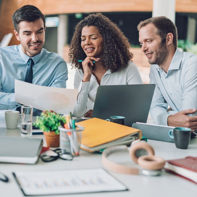 a group of people sitting around a table looking at a piece of paper